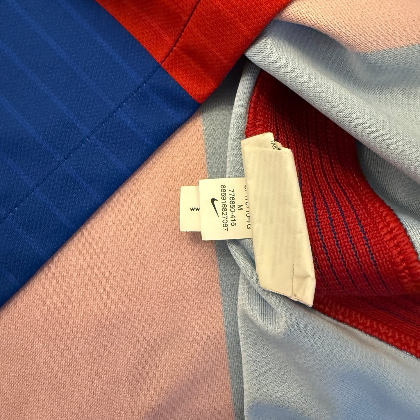 Close-up of a Nike tag 776850 on a multicolored fabric background