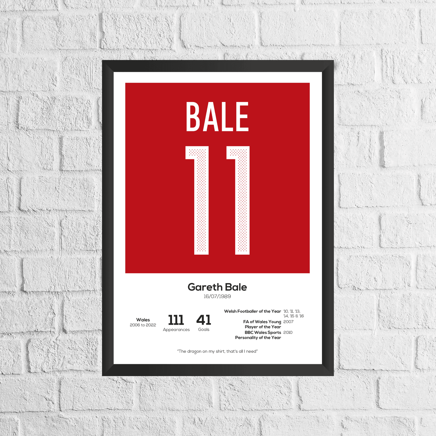Framed poster with 'BALE 11' on a red background, displayed on a white brick wall.