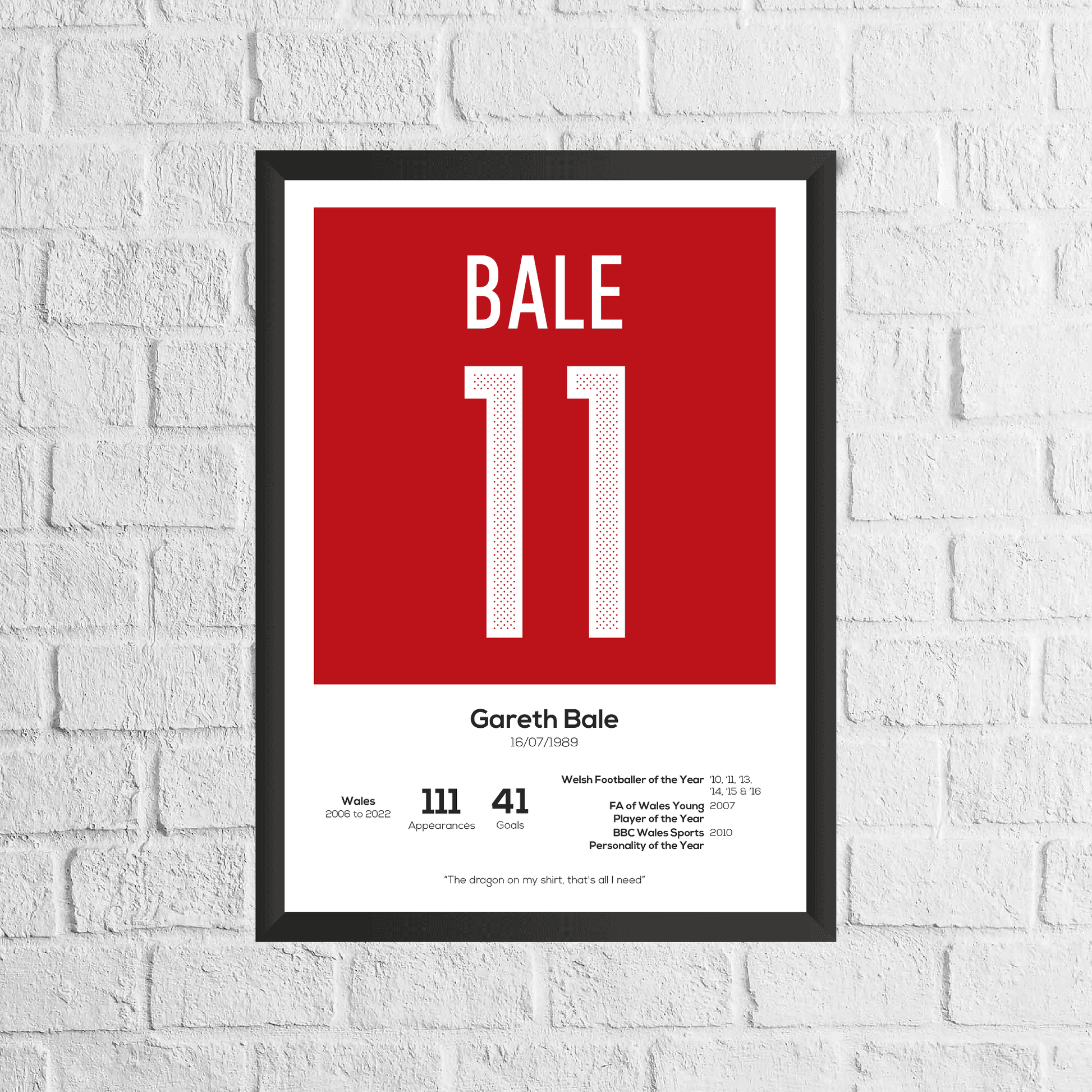 Framed poster with 'BALE 11' on a red background, displayed on a white brick wall.
