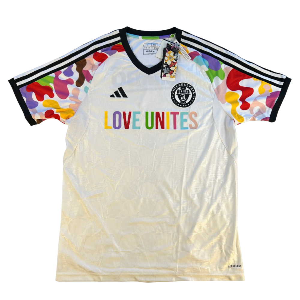 White sports jersey with colorful sleeves and 'LOVE UNITES' text, featuring Adidas logo. Philiadelphia_Union_20222023_Love_Unites_Shirt_front