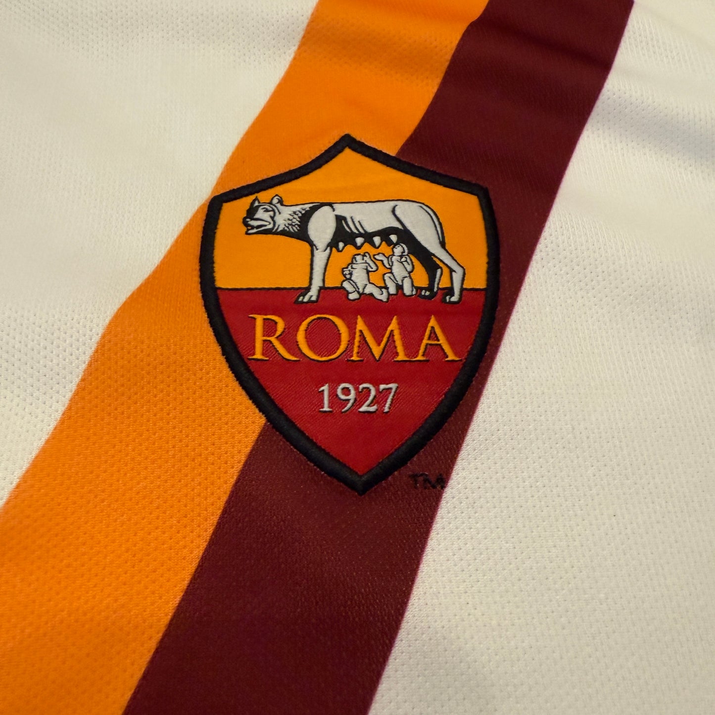 Close-up of the 2014 Roma logo with 'Roma' and '1927' on a striped background