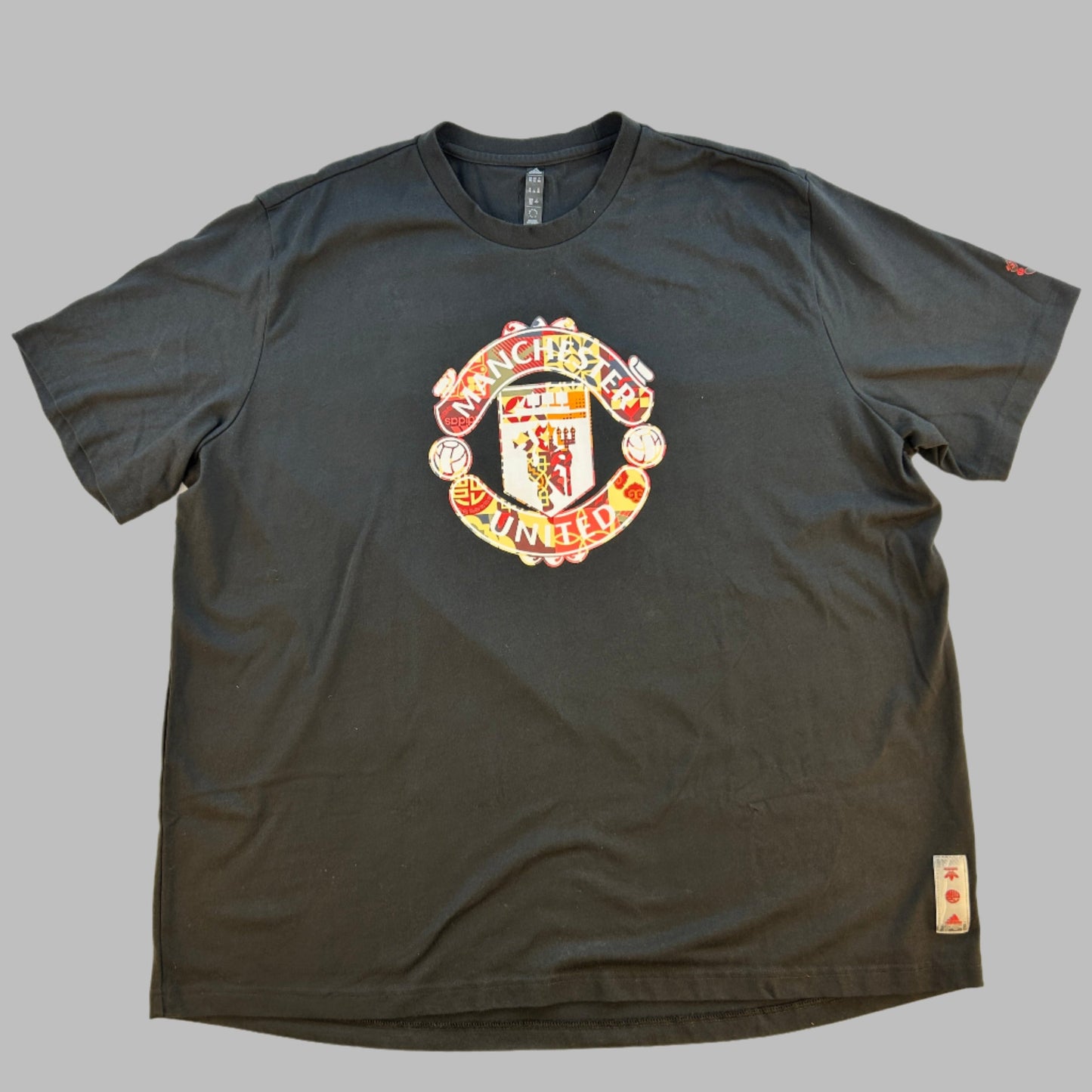 Manchester United Chinese New Year 2022 T-Shirt front featuring the Manchester United badge with a Chinese pattern 