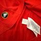 Close-up of a red shirt with an Adidas logo and tag code P47902 for the Spain 2010 Home Shirt