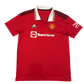 Red sports jersey with white TeamViewer branding on a white background. The jersey has a white collar and three black shoulder stripes. There is a white DCX technology on one sleeve. This is the Manchester United 2022-2023 Home Shirt