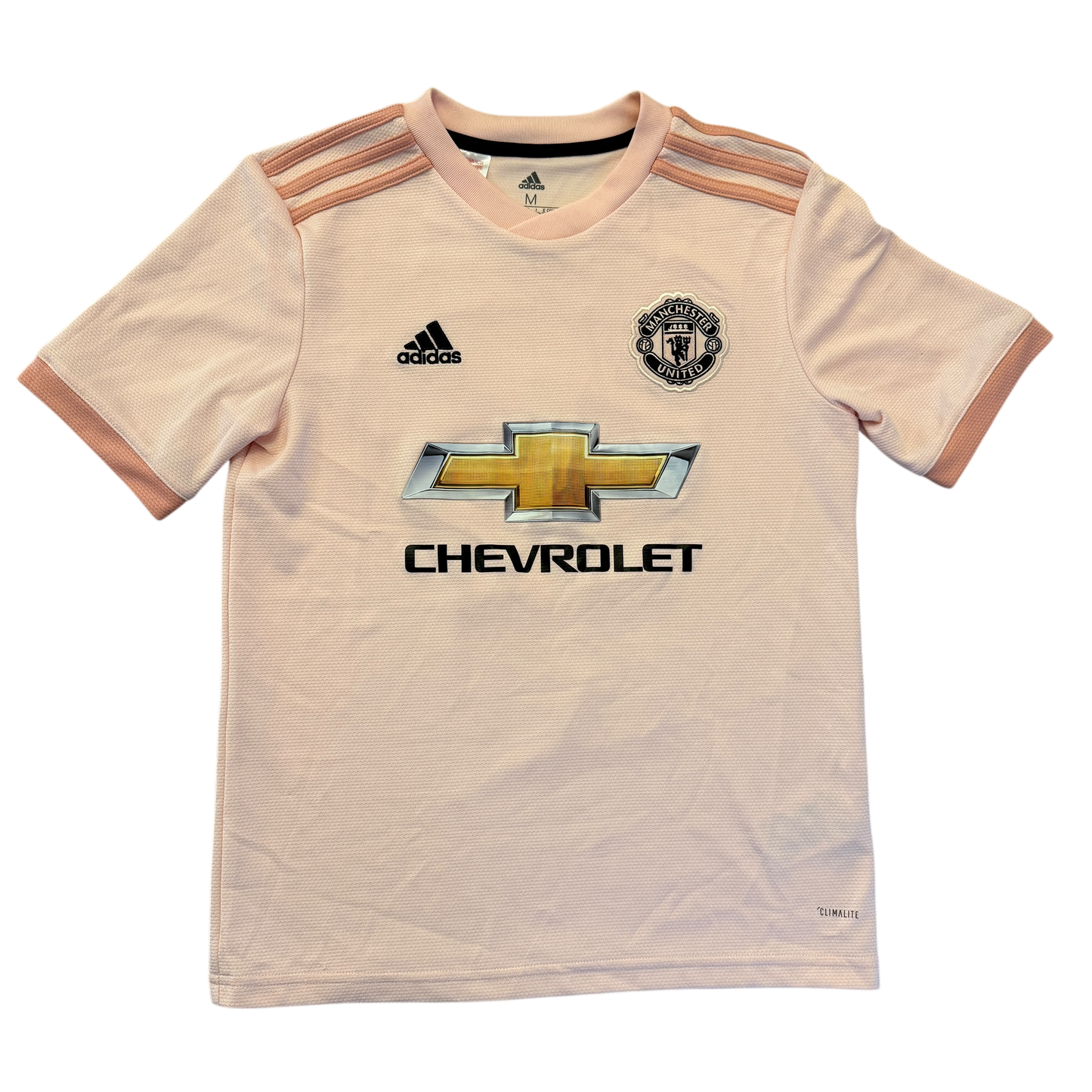 Pink youth sports jersey with Adidas, Manchester United, and Chevrolet logos on a white background