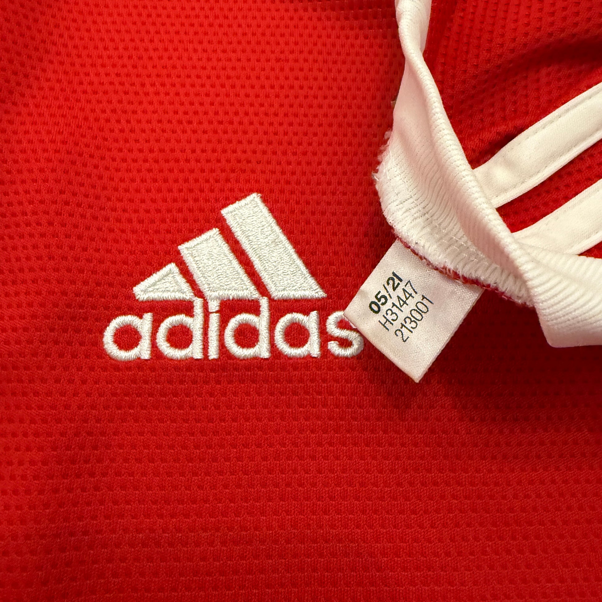 Red Adidas sports jersey with brand logo and tag.Code H31447 correct for the Manchester United 2021-2022 Home Shirt 