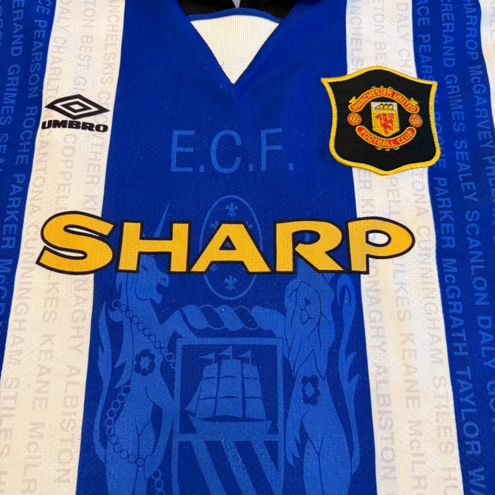 Blue sports jersey with branding and logos on a white background