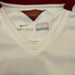 Close-up of a white sports jersey with a Nike label and text on the collar.