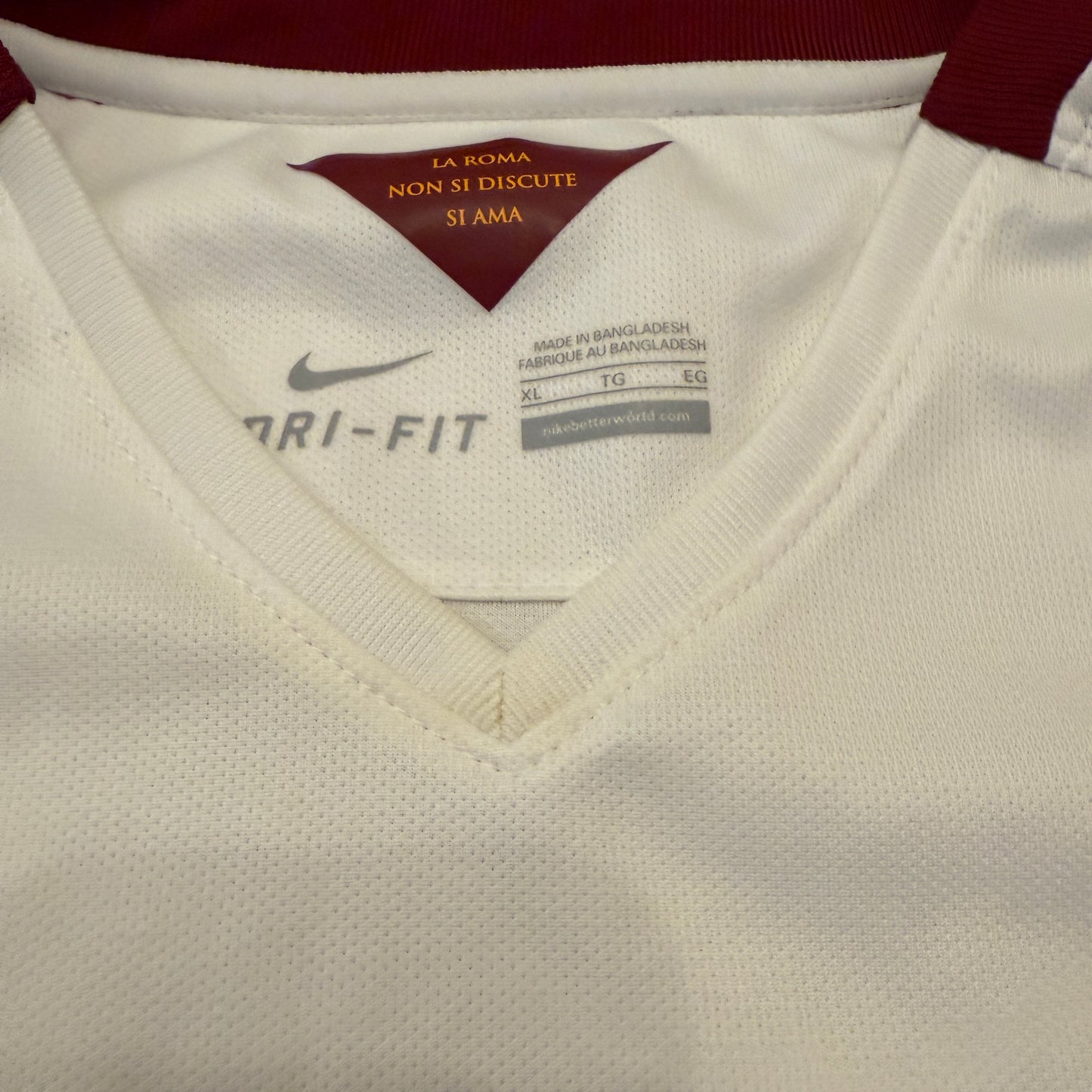 Close-up of a white sports jersey with a Nike label and text on the collar.