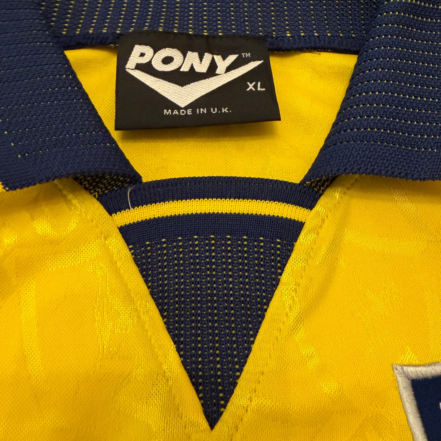 Close-up of a yellow and blue garment with a Pony label