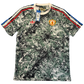 Camouflage-patterned Manchester United Stone Roses Icons Shirt with brand logos on a white background